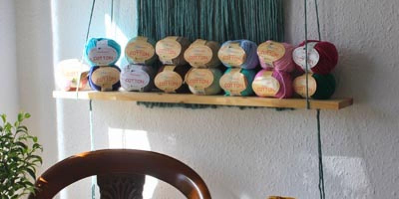 Grupo de ovillos para macramé colocados en estantería decorativa
